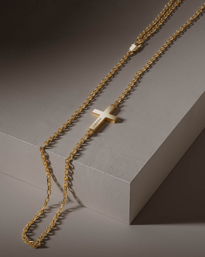 Side cross necklace in gold on a stone block