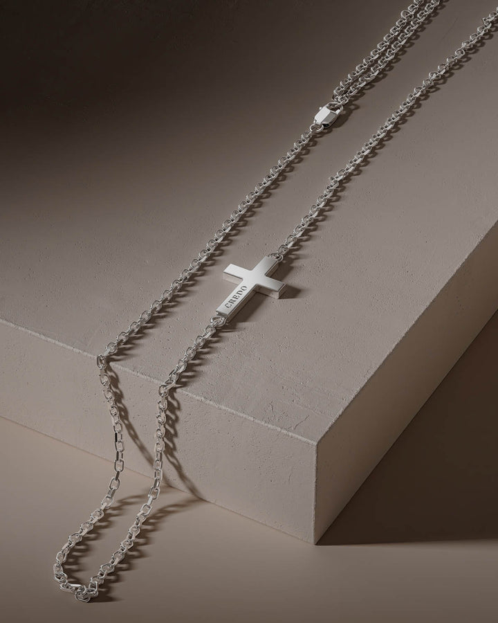 Side cross necklace in silver on a stone block