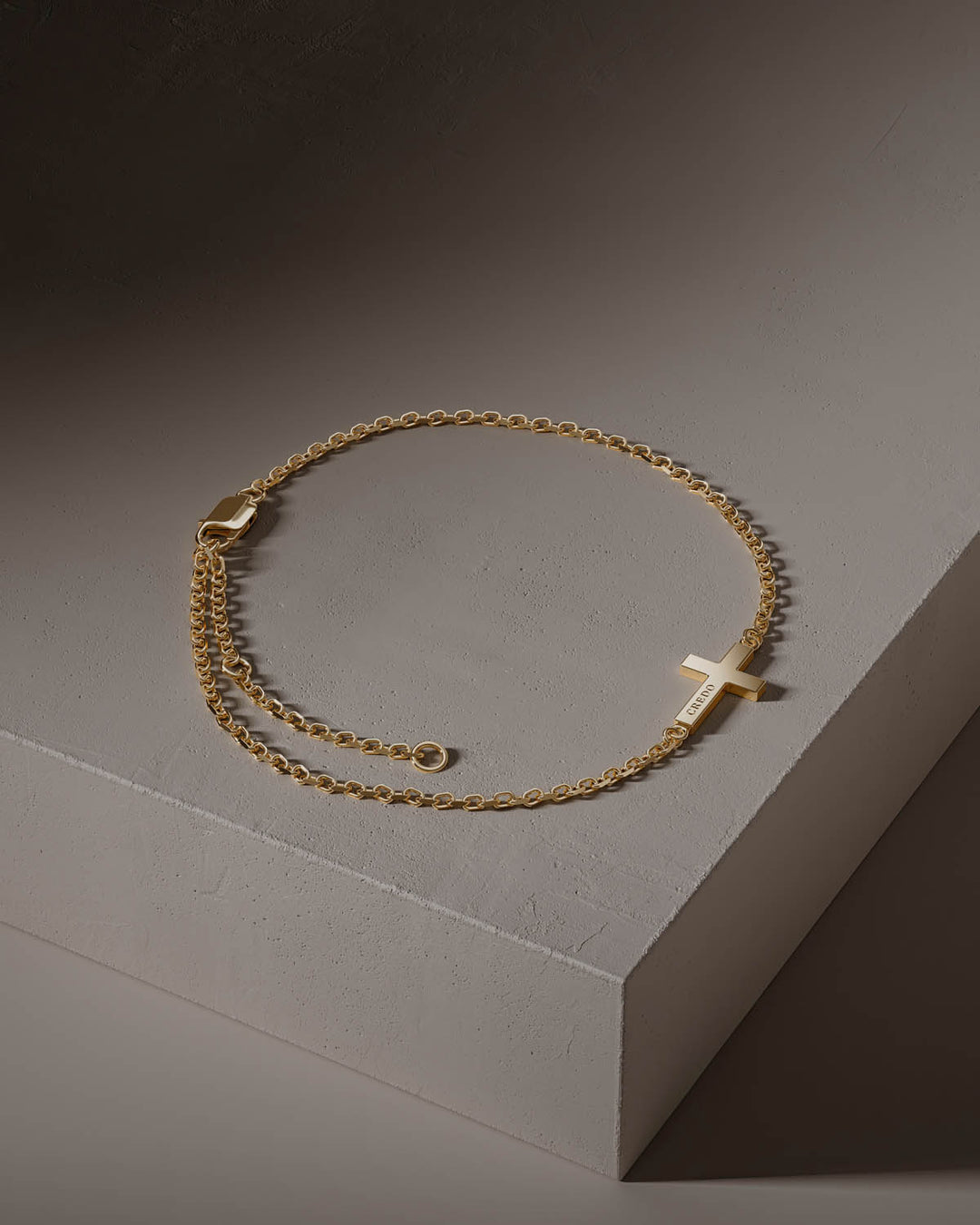 Side cross bracelet in gold with adjustable chain, full view