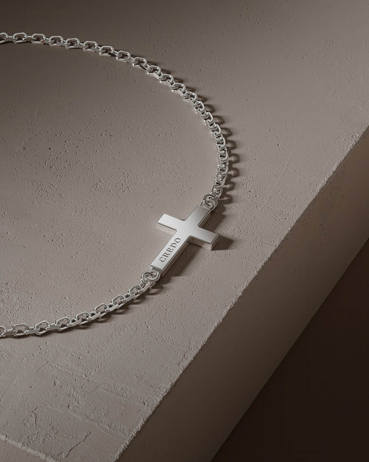 Side cross bracelet in silver, close-up of the cross on a stone block