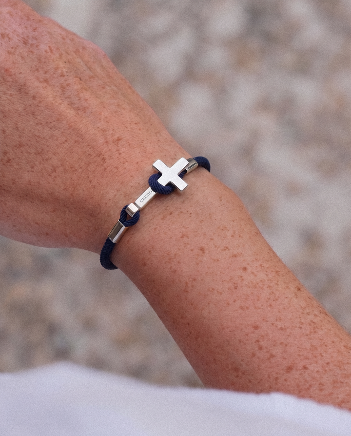 Women's Rope Cross Bracelet in navy blue with a silver cross, lifestyle view