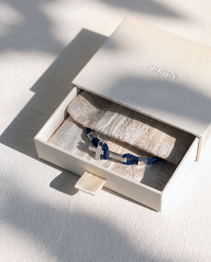 Credo gift box with a woven pouch and a rope cross bracelet inside