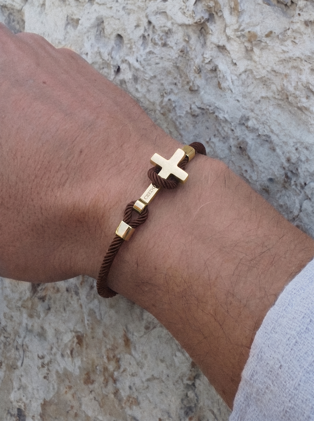Men's Rope Cross Bracelet in hickory brown with a gold cross, lifestyle view