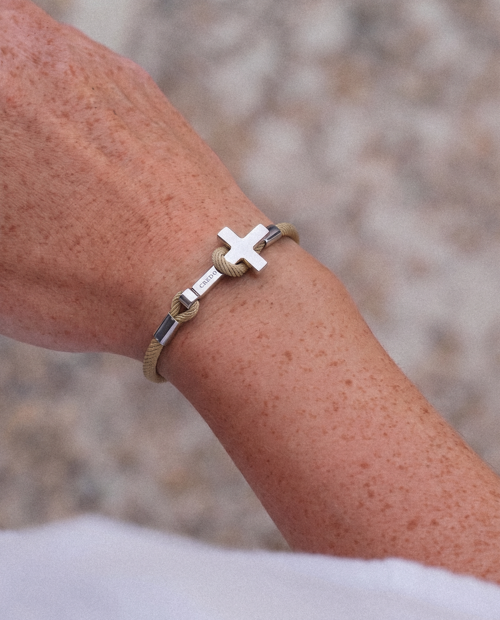 Women's Rope Cross Bracelet in khaki with a silver cross, lifestyle view