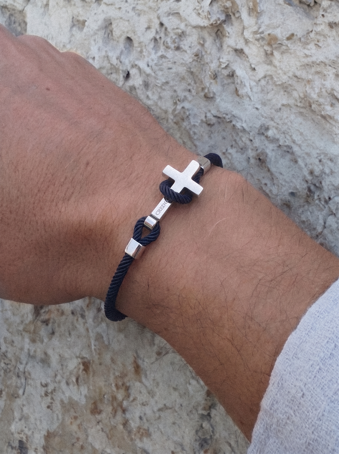 Men's Rope Cross Bracelet in navy blue with a silver cross, lifestyle view