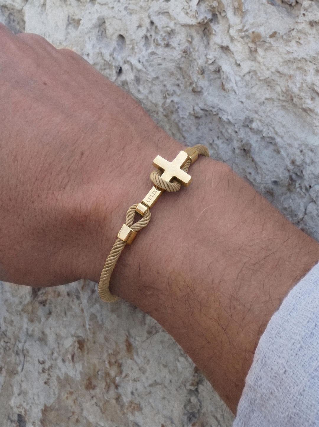Men's Rope Cross Bracelet in khaki with a gold cross, lifestyle view